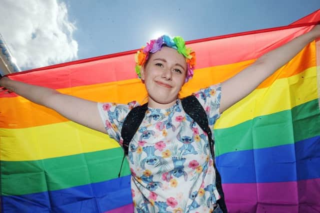 A Pride supporter flies the rainbow flag.