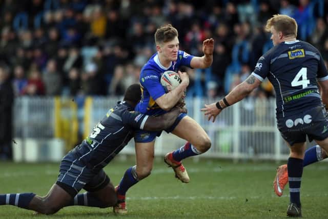 Leeds 
Rhinos' Liam Whitton is tackled by Featherstone's Ase Boas and Connor Carey.
 Picture: Jonathan Gawthorpe.