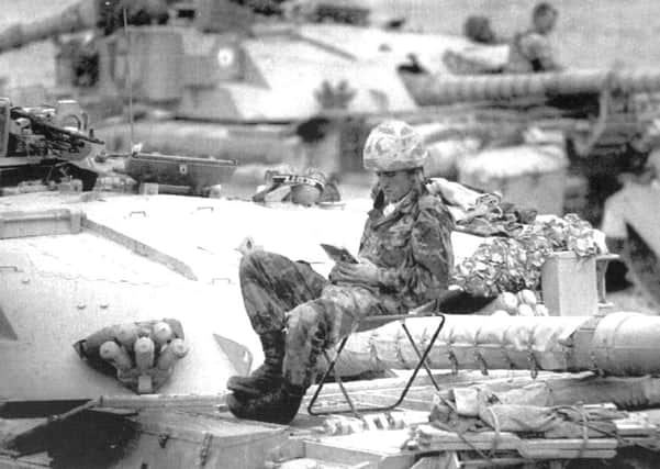 22nd Jan 1991. the Gulf. A British soldier from the 7th Armoured brigade reading a book on top of his Challenger tank.