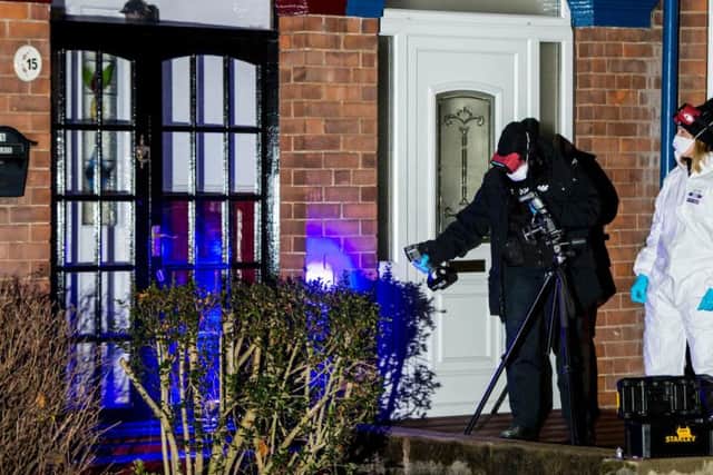 Crime scene investigators were seen on Sunday night swabbing a door at a property on Wellesley Avenue. PIC: SWNS