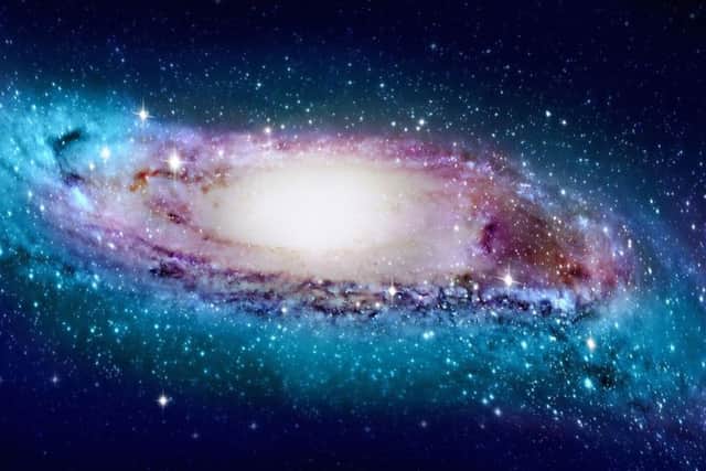 An artist impression of the Milky Way as the spinning spiral galaxy that is the sun's home is bent towards its edges, astronomers have discovered. PIC: PA