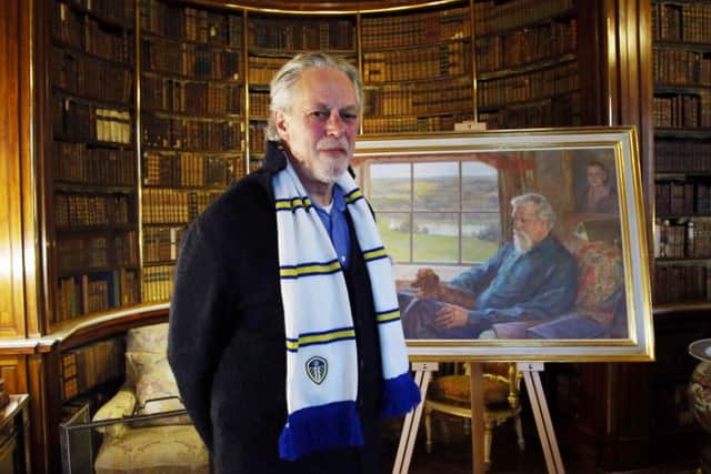 David Lascelles, the 8th Earl of Harewood, proudly wears a Leeds United scarf as he stands in front of a portrait of his late father.