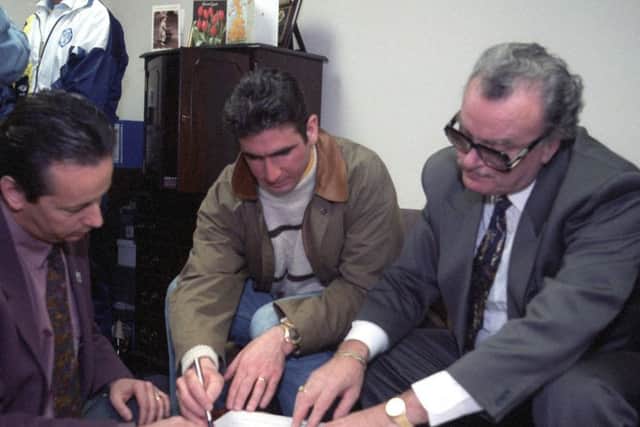 Famous French footballer, Eric Cantona, is pictured signing for Leeds United in February 1992. He is seen with then MD< Bill Fotherby, right, and Eric's French agent.

pic by Mike Cowling Yorkshire Evening Post