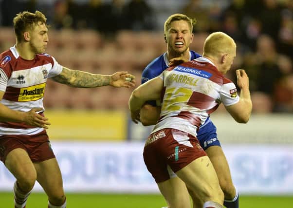 Matt Parcell is tackled by the Wigan defence.
