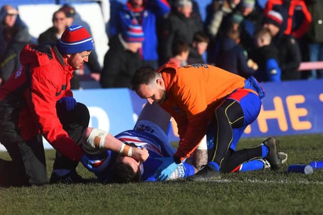Wakefield's Craig Huby receives treatment to his injured shoulder against St Helens.