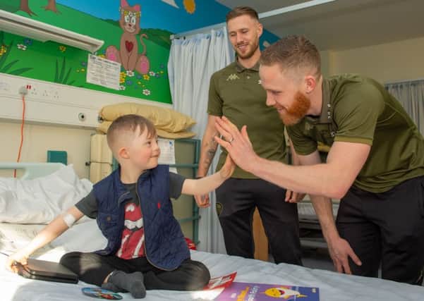 Leeds United stars Barry Douglas and Adam Forshaw make a new friend during the hospital visit.