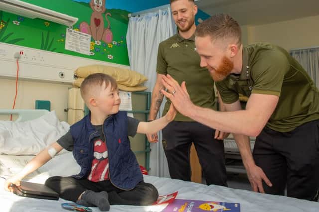 Leeds United stars Barry Douglas and Adam Forshaw make a new friend during the hospital visit.