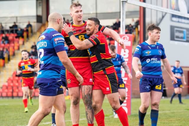 Dewsbury's Paul Sykes is congratulated by Lucas Walshaw after scoring a try against Swinton.