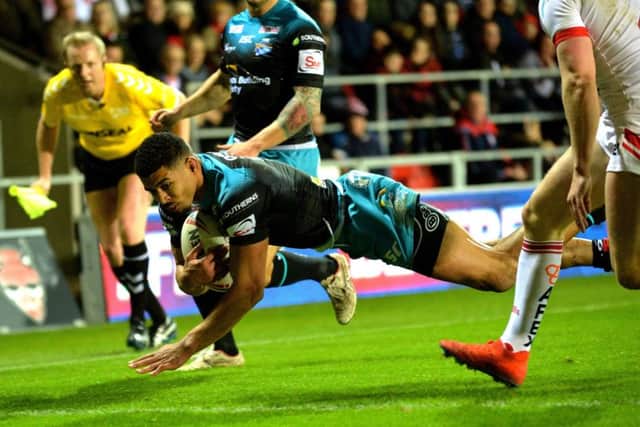Kallum Watkins dives over for the Rhinos' first try at St Helens.