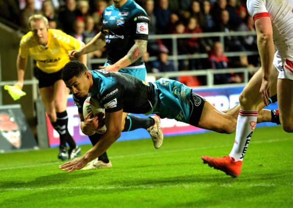 Kallum Watkins dives over for the Rhinos' first try at St Helens.