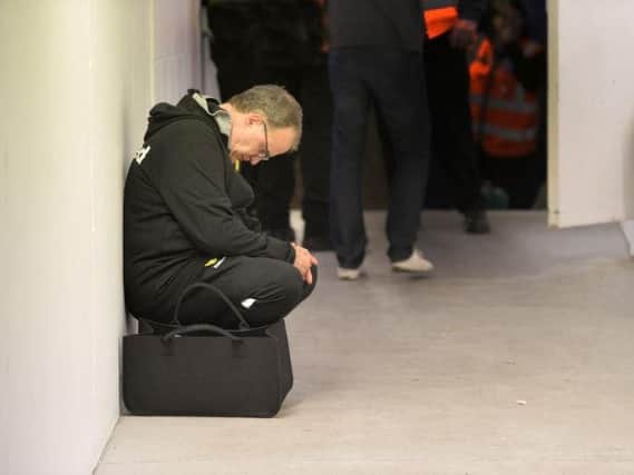 Leeds United head coach Marcelo Bielsa takes a moment to reflect outside the dressing room at Loftus Road.