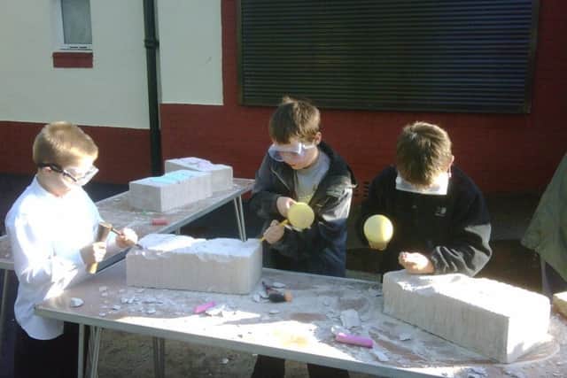 CHIPPING AWAY: Youngsters doing a stone carving session.