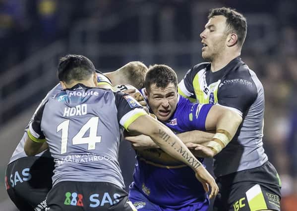 Leeds Rhinos' Trent Merrin is tackled by Wakefield's Justin Horo and Keegan Hirst.
