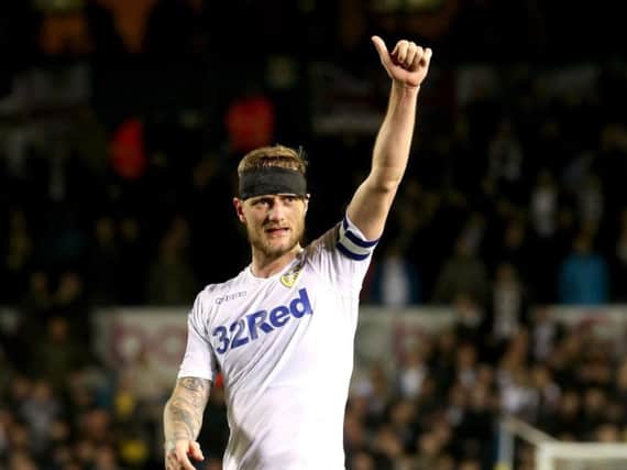 A bandaged Liam Cooper salutes the crowd at Elland Road after Leeds United's crushing win over West Brom.