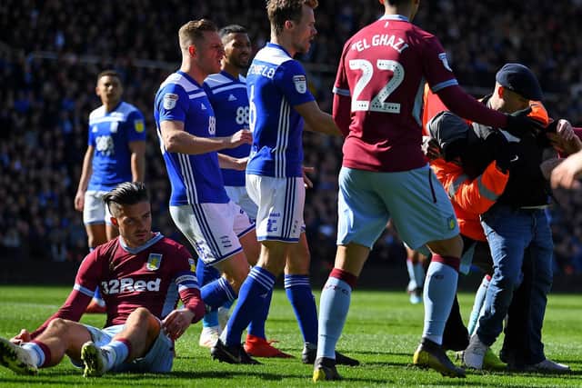 A Birmingham City fan attacks Aston Villa midfielder Jack Grealish at St Andrews.