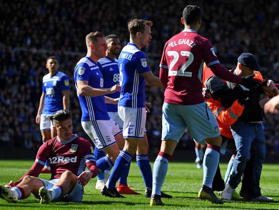 A Birmingham City fan attacks Aston Villa midfielder Jack Grealish at St Andrews.