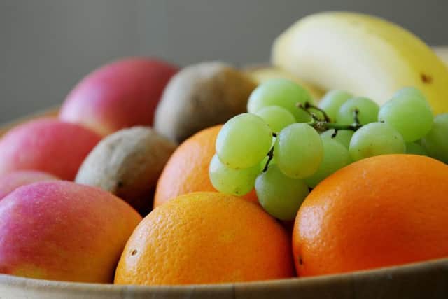 Grapes, Oranges, apples bananas and Kiwifruit in a fruit bowl.
