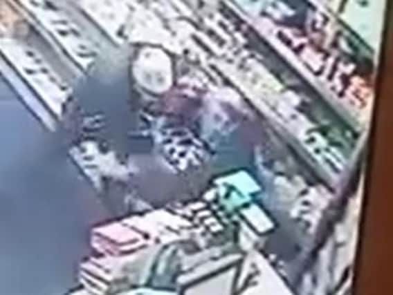 A Batley shopkeeper had to wrestle a man wielding a knife from his store yesterday.