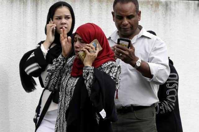 People wait outside a mosque in Christchurch waiting for news about loved ones caught up in two mass killings.