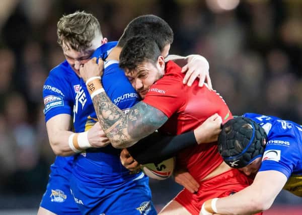 London's Jay Pitts is tackled by Leeds' Tui Lolohea and Matt Parcell.