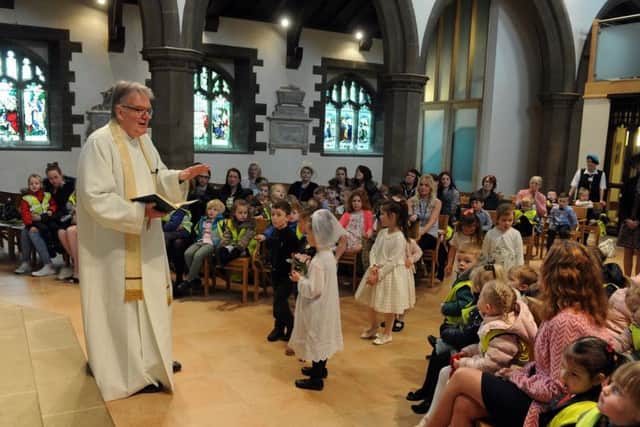 Reverend Paul Walker with nursery and reception pupils at Drighlington Primary School taking part in a mock wedding at St Paul's Church, with pupils taking on the roles of bride, groom, best man, ushers and bridesmaids.  Picture Tony Johnson.