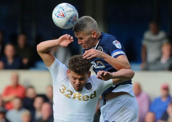 Former Leeds striker Steve Morison climbs to beat Kalvin Phillips in the air.