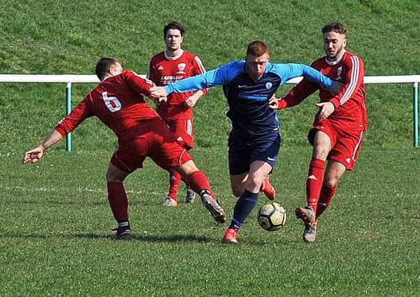 Joe Cryer wins the ball for Wortley despite being crowded out by Shire defenders. PIC: Steve Riding