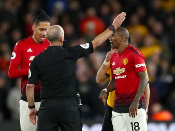 Referee Mike Dean sends off Manchester United's Ashley Young, right, at Molineux.