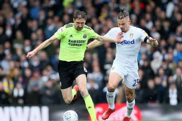 Leeds United's Kalvin Phillips tussles with Sheffield United's Chris Basham.