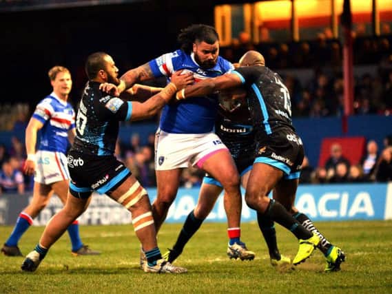 Huddersfield's defence tries to stop the charging Wakefield forward Dave Fifita. (PIC: BRUCE ROLLINSON)
