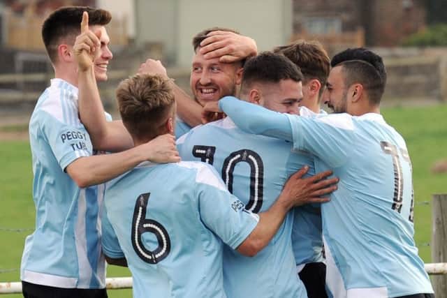 Liam Moore, facing, is mobbesd after heading home the winner. PIC: Steve Riding