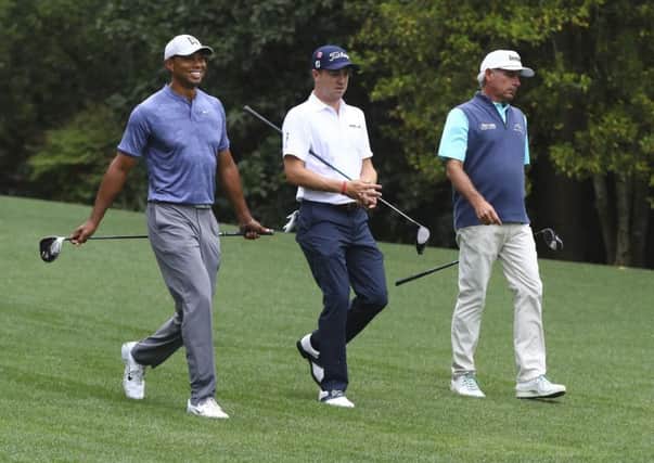 Tiger Woods, Justin Thomas and Fred Couples, from left, walk down the 11th fairway at Augusta. Picture: Curtis Compton/AP