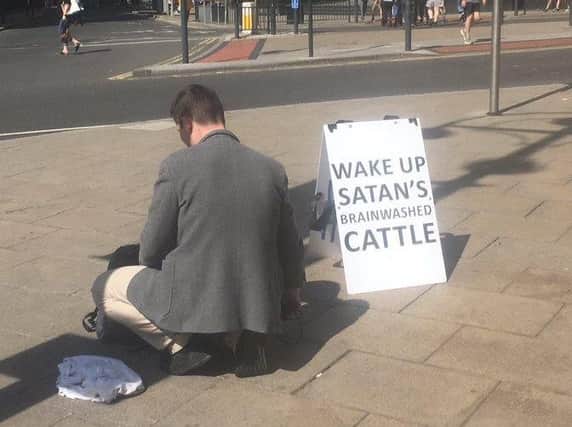 Protester with unusual sandwich board sign tells Leeds to "wake up", branding the public "Satan's brainwashed cattle"