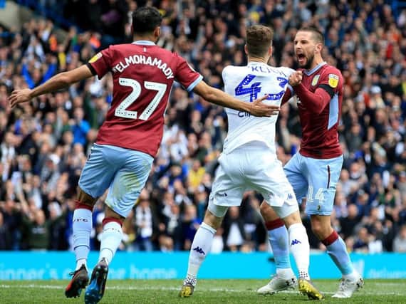 Mateusz Klich and Conor Hourihane clash after Leeds United's opening goal against Aston Villa at Elland Road.