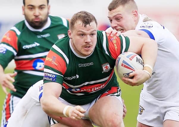 Hunslet's Tom Ashton tackled by Workington's Sean Penkywiecz  and Tom Curwen during the 1895 Cup clash on Saturday.