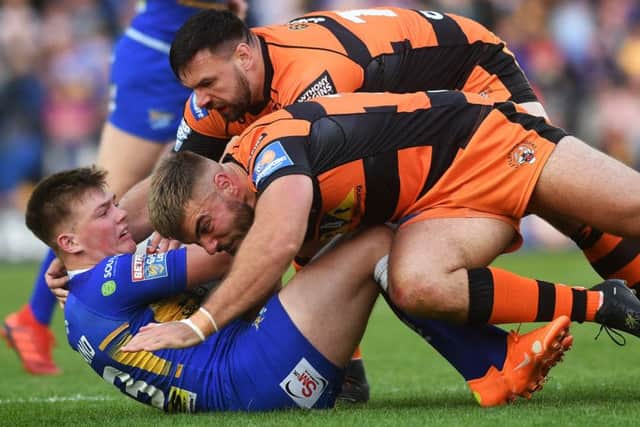 Rhinos' Callum McLelland is tackled by Tigers' Matt Cook and Mike McMeeken.