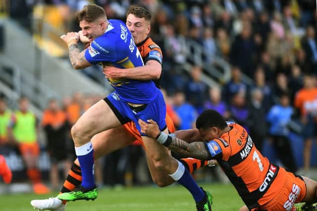 Liam Sutcliffe is tackled by Jake Trueman and Peter Mata'utia.