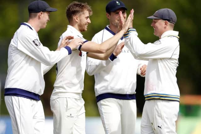Ben Coad (2nd L) of Yorkshire enjoys a high five with Gary Ballance after taking the wicket of Ollie Robinson.