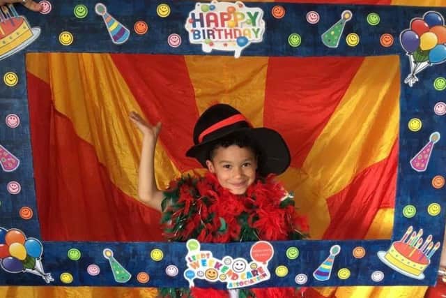 HAPPY BIRTHDAY: A youngster poses with an apt picture frame at the party.