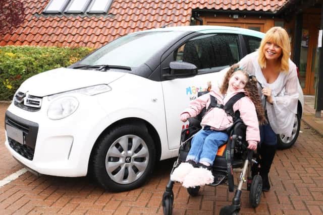 Christine Talbot launches the Martin House car raffle with the help of Lacie-Lea Rennie.