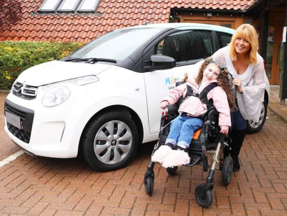 Christine Talbot launches the Martin House car raffle with the help of Lacie-Lea Rennie.