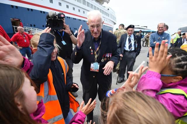 Veteran Jack Mortimer, 95, from Leeds, sings 'Baby Shark' with local school children after disembarking the MV Bouddica at Poole. PIC: PA