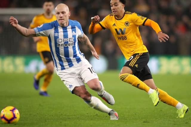 Helder Costa battles with Huddersfield Town's Aaron Mooy.