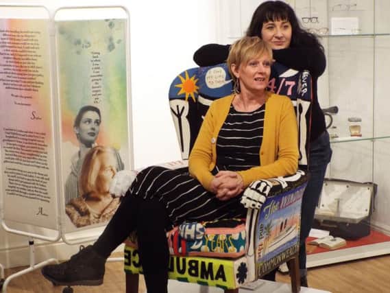 Space2 project coordinators Jelena Zindovic (standing) and Jane Morland, try out the new chair which is adorned with memories and tributes to the NHS
