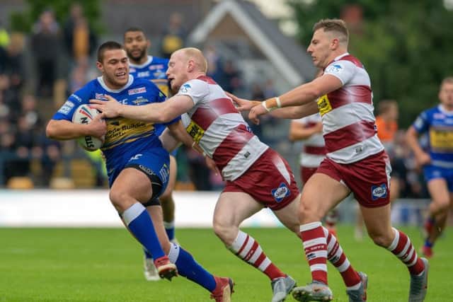 Leeds Rhinos' Tui Lolohea's run is held by Wigan's Liam Farrell.
 Picture: Bruce Rollinson