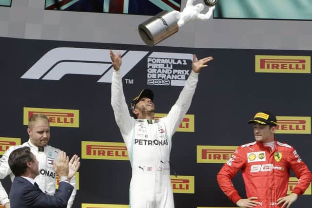 Mercedes driver Lewis Hamilton, center, of Britain, celebrates on the podium Picture: AP/PA.