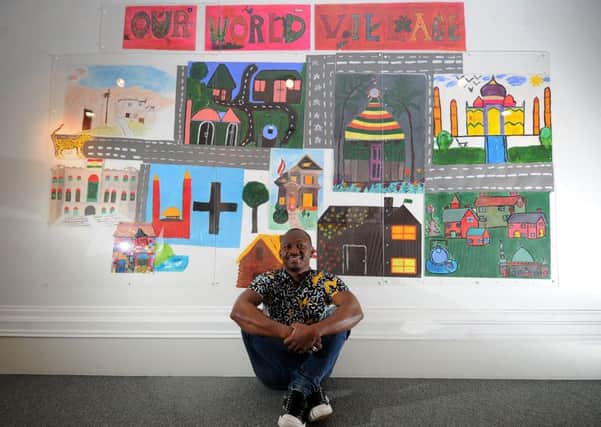 EXPRESSION: Artist Ousmane Batebou pictured with some of his art at the exhibition.
