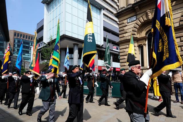 Flag bearers march down Commercial Street in Leeds city centre.