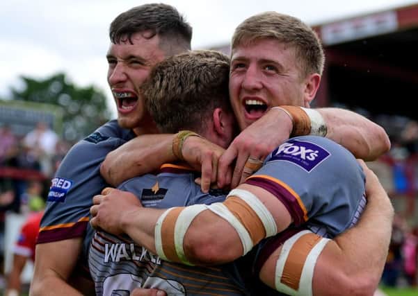 Sam Wood and Jack Downs celebrate with Batley try scorer Niall Walker.