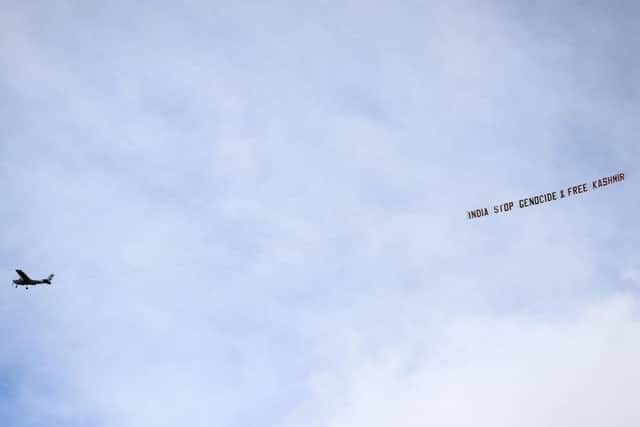 A plane flies over with a banner reading ' India stop Genocide & free Kasshmir' during the ICC Cricket World Cup group stage match at Headingley, Leeds. Picture: PA